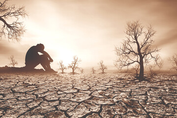 Concept of global warming and drought. People are sitting in despair because of the drought. a...