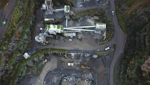 Les Vardes Quarry Guernsey showing quarrying  plant diggers and lorries with birds flying overhead  rising to reveal countryside setting