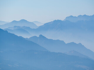 Amazing aerial landscape at the Alps in winter season. Foggy and humidity in the air. Italian alps. Silhouette of the mountains and summits