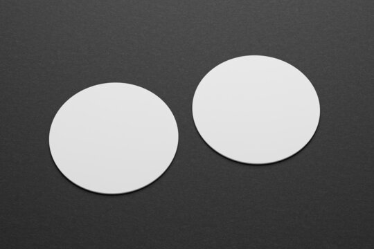 3d mockup of a round business card on a black paper background