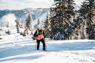 Mountaineer backcountry ski walking ski woman alpinist in the mountains. Ski touring in alpine...