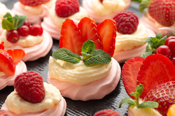 fruit meringue cake Pavlova with fresh berries decorated mint on black background