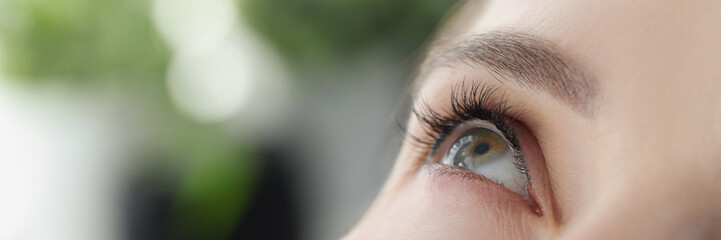 Woman dripping moisturizing drops into her eye closeup