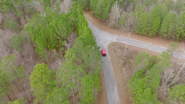 Aerial shot following a Jeep Wrangler on a Rural Road