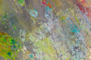 colorful creative motley background: smudged residues of oil paints on a wooden palette, short focus, selective blur