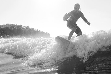 Naklejka premium Young surfer with lean muscular body rides the tropical wave