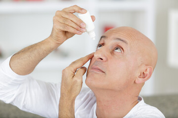 man self administering eye drops