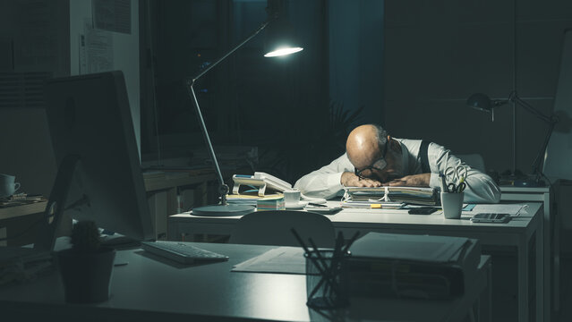 Stressed businessman sleeping at desk