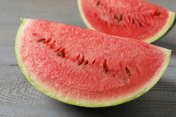 Slices of tasty ripe watermelon on grey wooden table, closeup