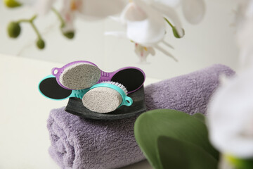 Pedicure tools with pumice stones and towel on white table