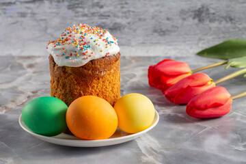 Easter cake, eggs and tulip flowers on kitchen table.