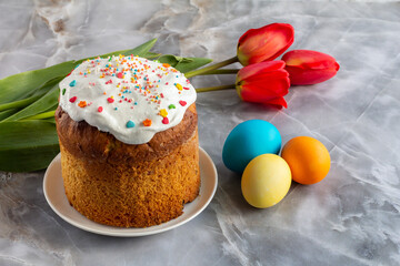 Easter cake, eggs and tulip flowers on kitchen table.