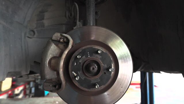 4K, Car wheels were removed from wheel arches to repair car brakes in a garage.
