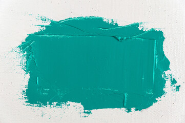 wide stroke of green paint on a white coarse weave art gauze close-up, toning, free space