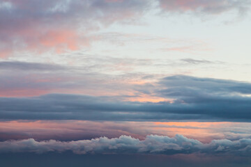 Naklejka na ściany i meble Blue sky background with tiny sunset clouds in summer season. Cloud texture