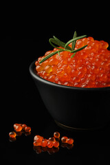 Delicious red caviar and rosemary on black background, closeup