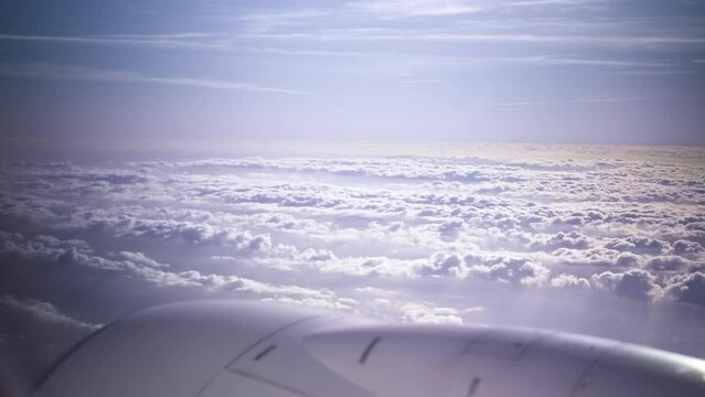 Plane flying above huge white clouds window view