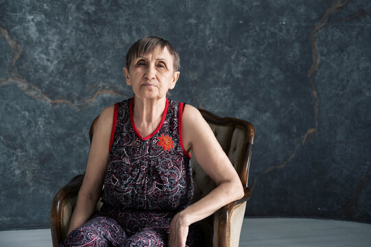 portrait of nice looking elderly woman sitting on armchair