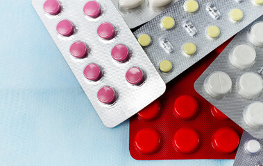 Assortment of medical pills in a package, on a light background, no people, selective focus,