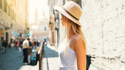 Young attractive smiling girl tourist exploring new city at summer