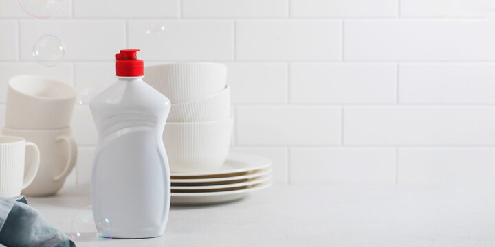 A mockup of a white plastic bottle with liquid dishwashing detergent. Banner. Copy space.