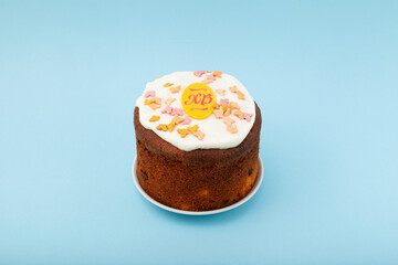 Glazed easter cake decorated with candied fruits on light blue background. Happy Easter Holidays