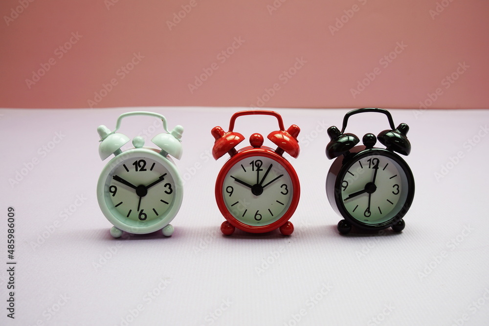 Poster alarm clocks with different time composition on pink background