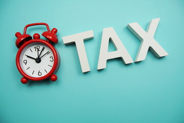Tax Time alphabet letters with alarm clock on blue background