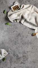 Empty gray stone background with textile and ingredients. Food background in rustic style. Cement table with kitchen towel and spices. Aesthetic minimal background.