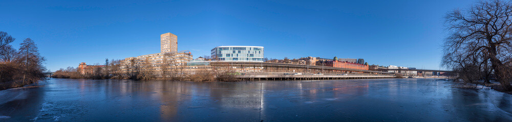 Naklejka premium Panorama over the canal Karlbergskanalen, apartment and office houses by the train tracks and the traffic route Karlbergsleden a winter day in Stockholm