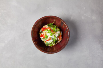 Chef salad with crab, quinoa, vegetables and edamame beans on dark homemade ceramic bowl. Salad bowl with crab, avocado, cream sauce in modern serveware. Modern dishware on concrete background.