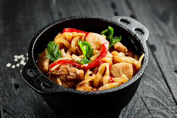 Japanese stir fryed udon noodles in wok. Udon noodle with chiken and vegetables on wooden...