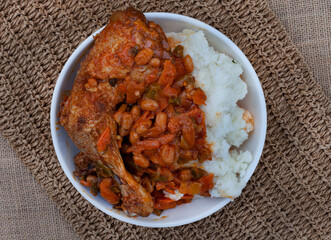 Traditional south African pap and roasted chicken, maize meal with chicken piece and chakalaka sauce