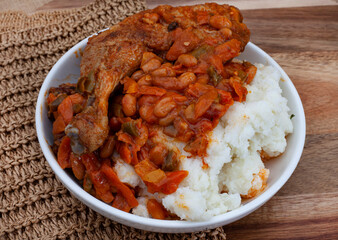 Traditional south African pap and roasted chicken, maize meal with chicken piece and chakalaka sauce