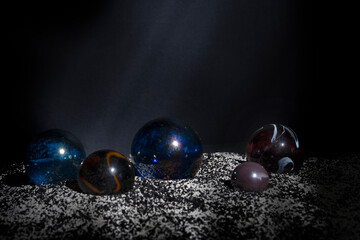 Spheres made of transparent material in different sizes and colors on a loose lining of a two-tone fine mixture