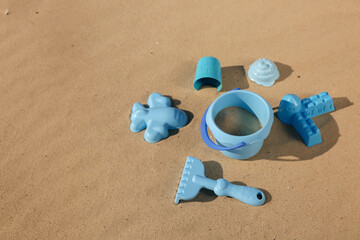 Fototapeta na wymiar Set of plastic beach toys on sand, space for text. Outdoor play