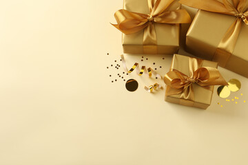 Obraz na płótnie Canvas Beautifully wrapped gift boxes and confetti on beige background, flat lay. Space for text