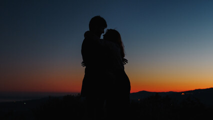 Fototapeta na wymiar Silhouette of boy and girl hug each other tightly