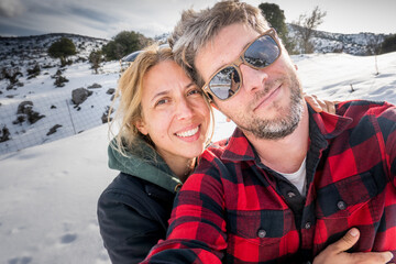 Couple taking selfie on snow covered mountain