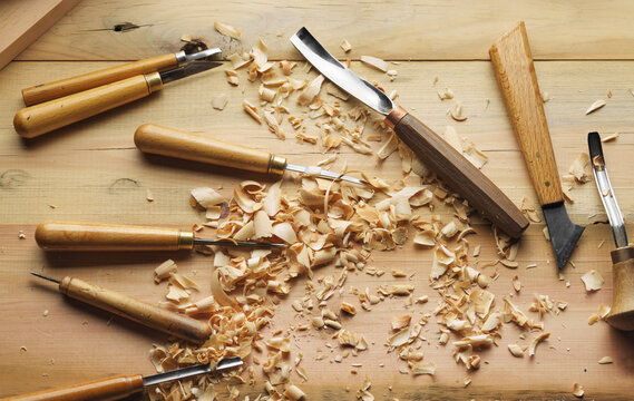 Woodworker's desk with cutters. Woodworking tools and shavings on a wooden table. Top view. Wood carving process.