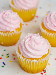 macro photography. Festive composition. Multi-colored confetti is scattered on a white background. Appetizing muffins with pink fruit cream. Celebration. birthday, romantic date.