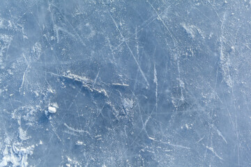 Empty ice rink with skate marks after the session outdoor. skating ice rink texture covered with snow in daylight. Close up of blue ice rink floor, copy space