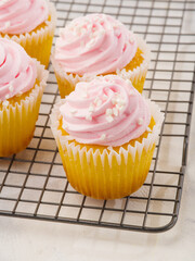 macro photography. Cupcakes with cream on a metal grill. Sweet food, many calories, carbohydrates, children's party, birthday, supermarket, pastry shop, cookbook.