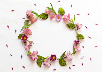 Round floral frame of spring alstroemeria flowers on white backdrop. Background for congratulatory text, announcement, invitation or advertising. Romantic greeting concept. Flat lay, copy space, blank