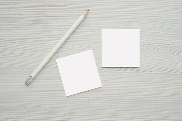 Two small square cards mockup for design presentation, minimal background with white pencil.
