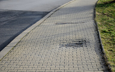 dips and sidewalk ripple. damage to surface of concrete tiles caused by damage to sewer, poor compaction by vibrating rollers. pressure tests should be carried out before construction road begins