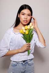 woman with Asian appearance with a bouquet of flowers smile close-up studio model unaltered