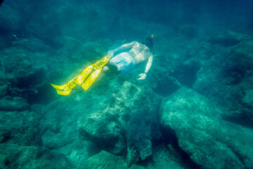 Boy in diving flipper swimming undersea