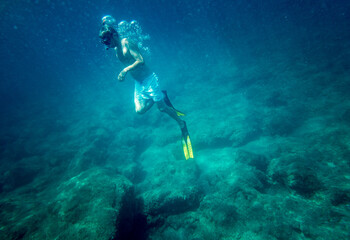 Fototapeta na wymiar Boy snorkelling with diving flipper undersea
