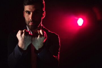 Close up photo of man showing two fists on pink and black background.